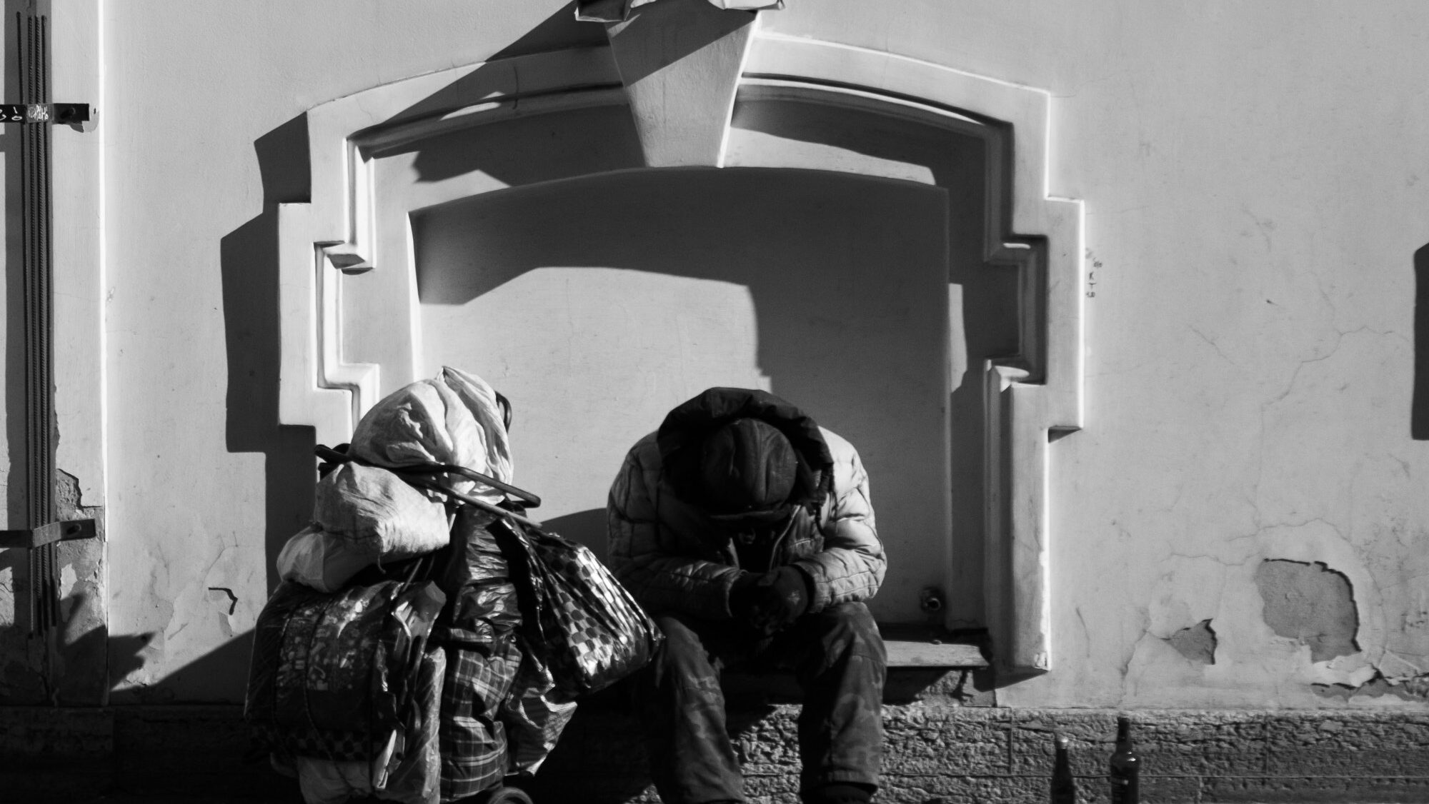 A homeless man sitting next to his belongings